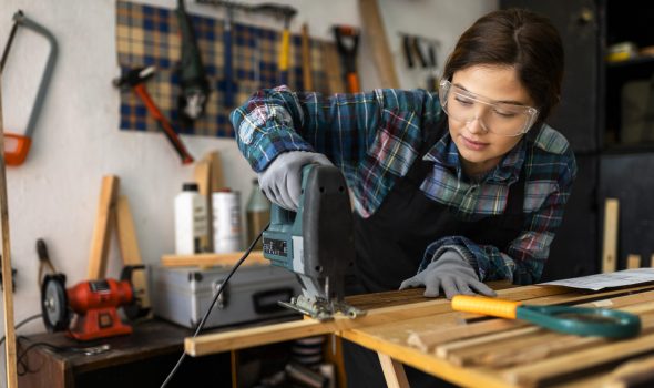 female-working-workshop-with-hammer-drill